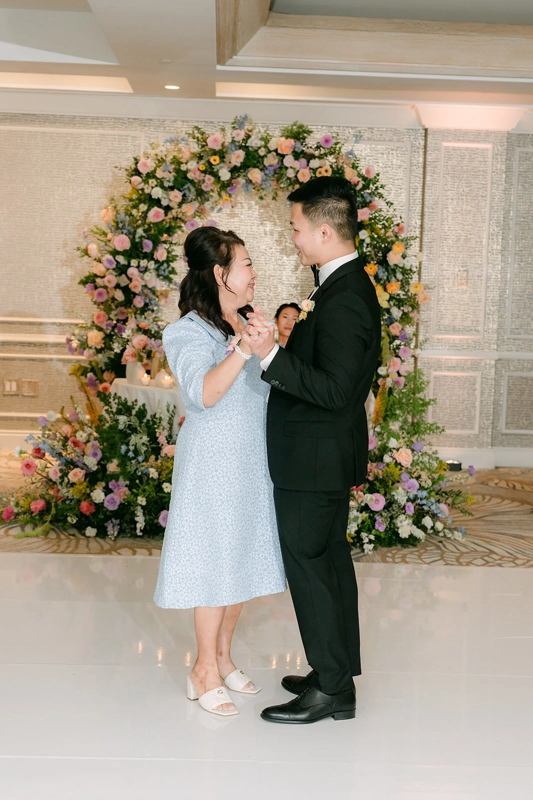 Mario and a family member sharing a dance on the white floor, photographed by One and Only Production