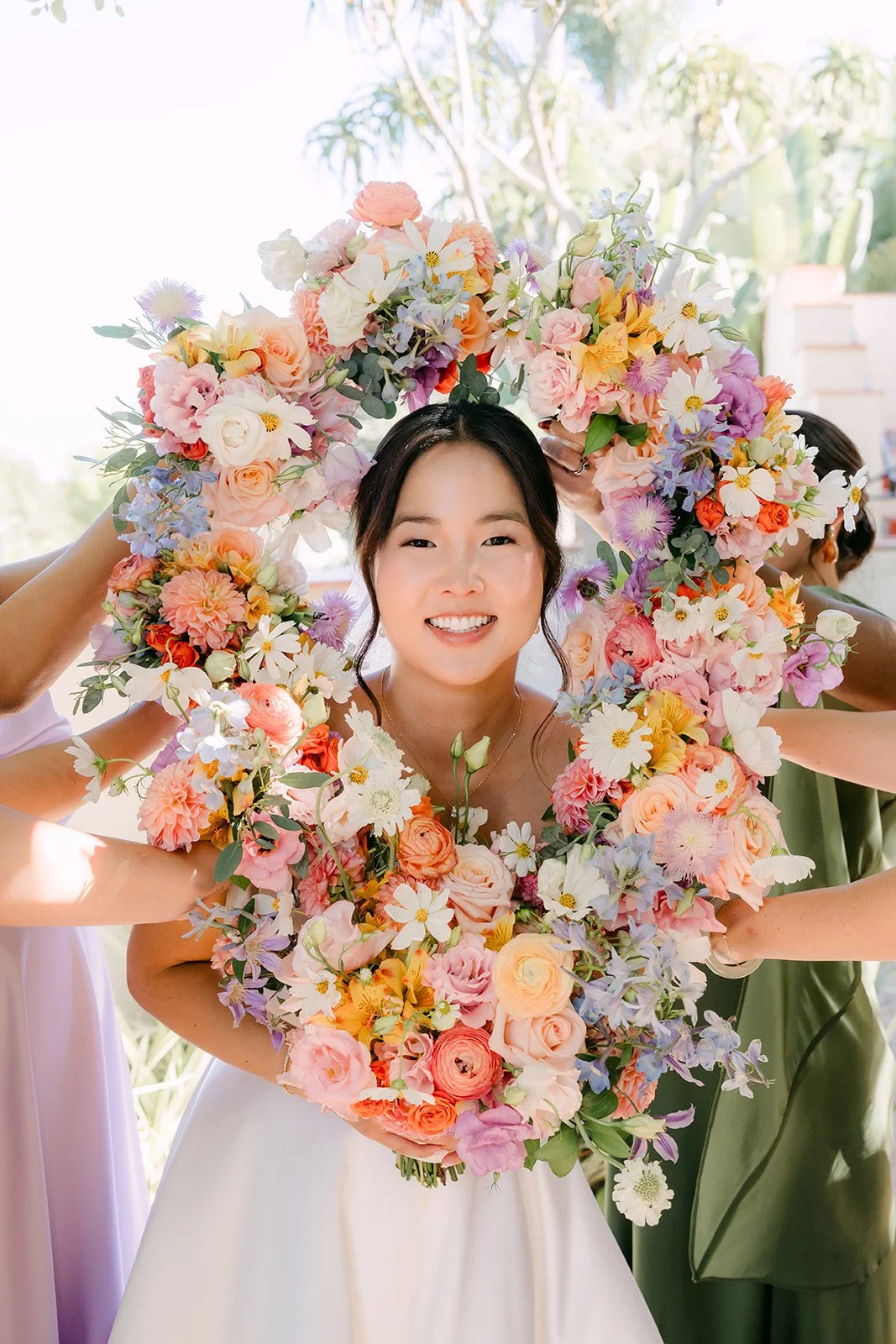 Saya peeking through a colorful floral garland