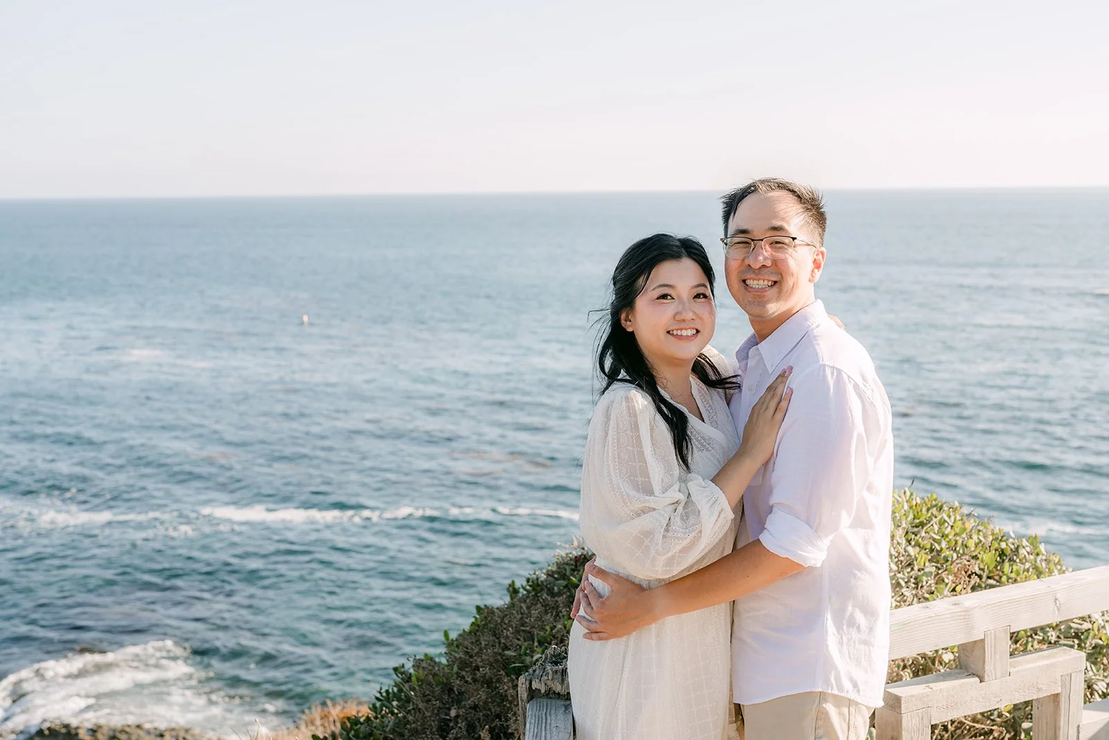Constance and Lawrence smiling with the ocean behind them.