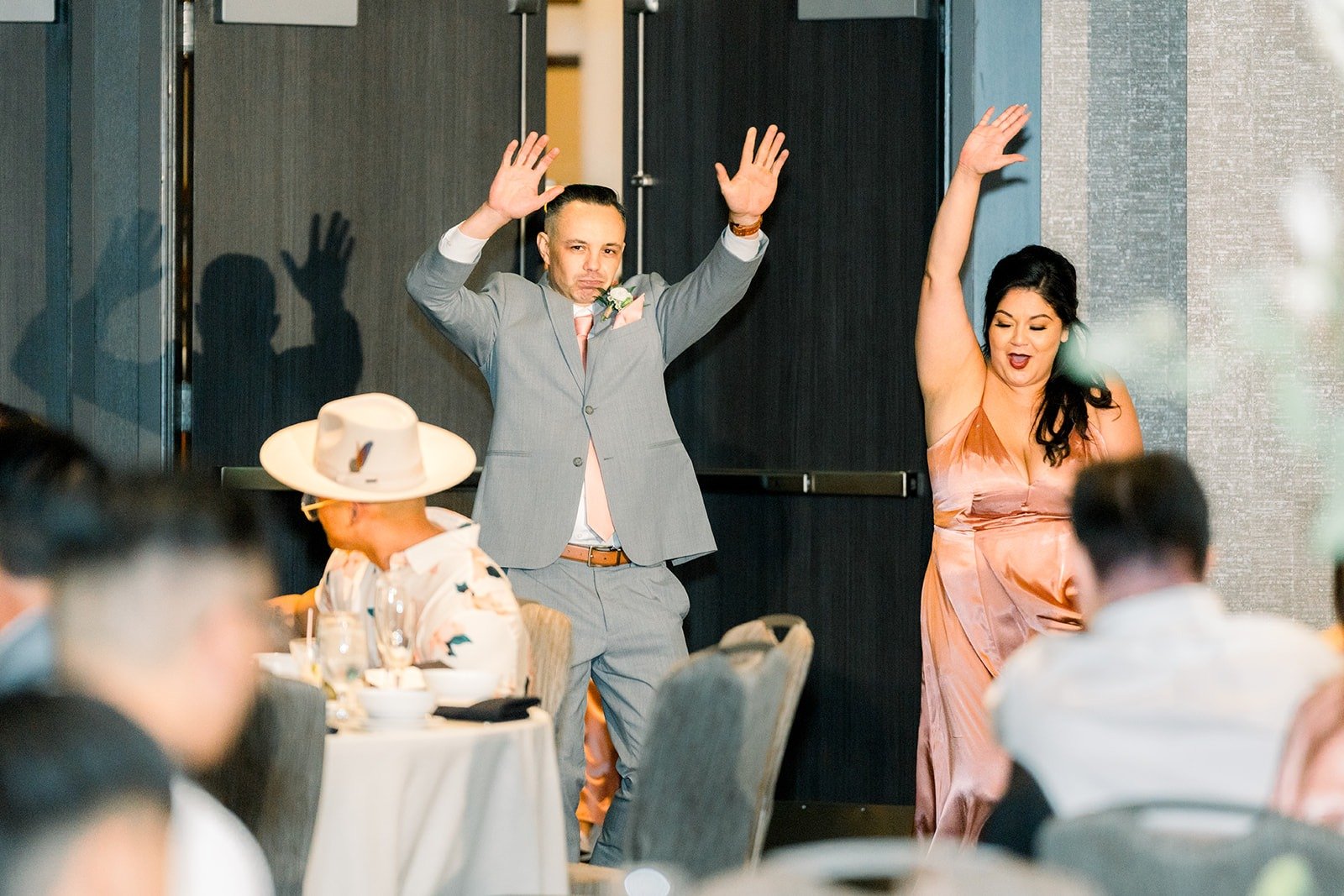 A groomsman throws his arms up during the grand entrance