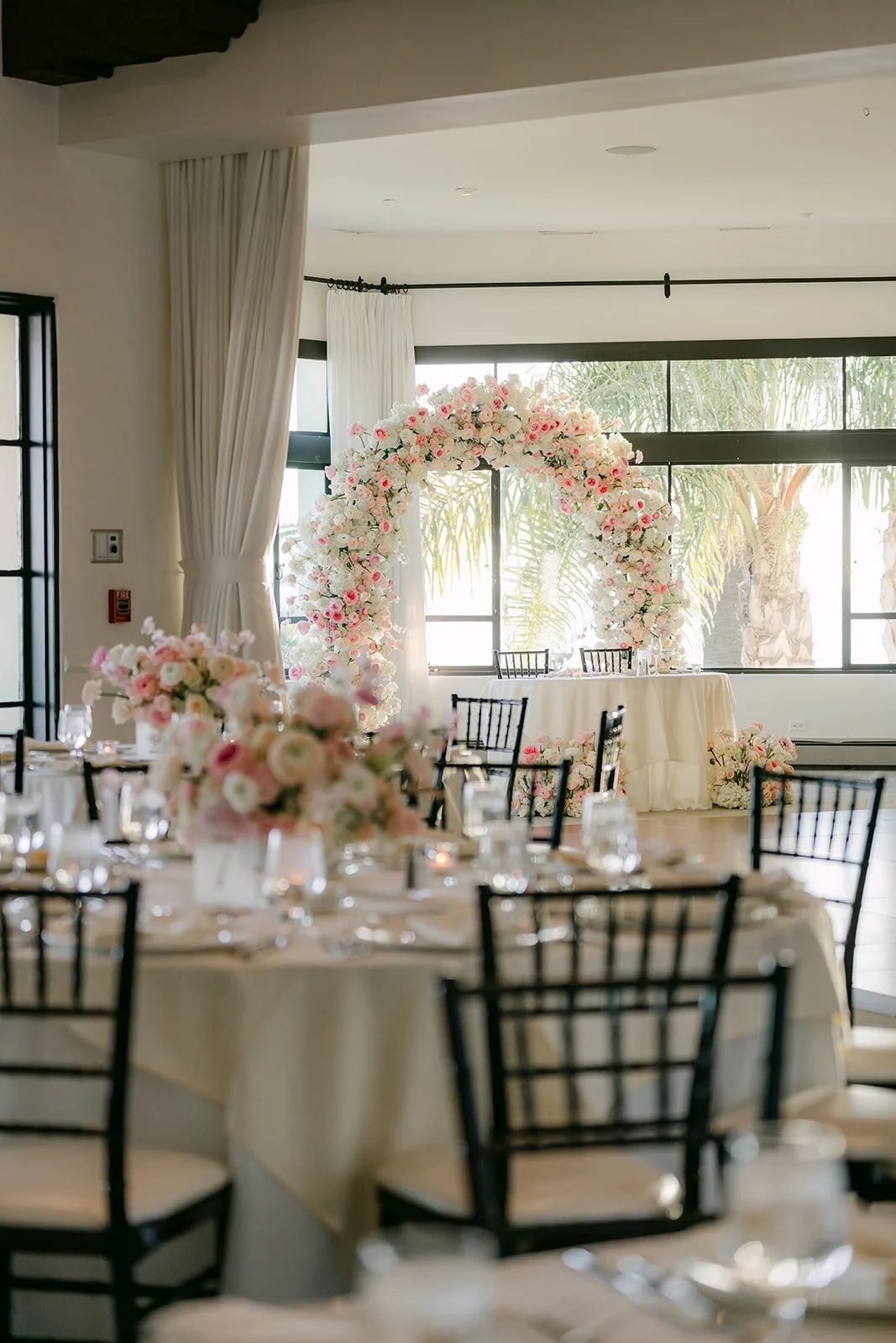 Reception tables with the floral arch in the background