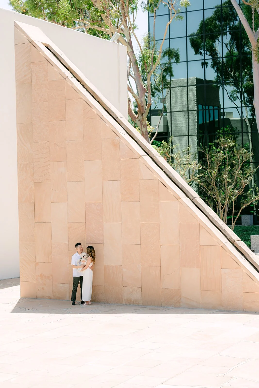 Stephanie, Alan and Tofu dwarfed by a tall sandstone sculpture at Noguchi Garden.
