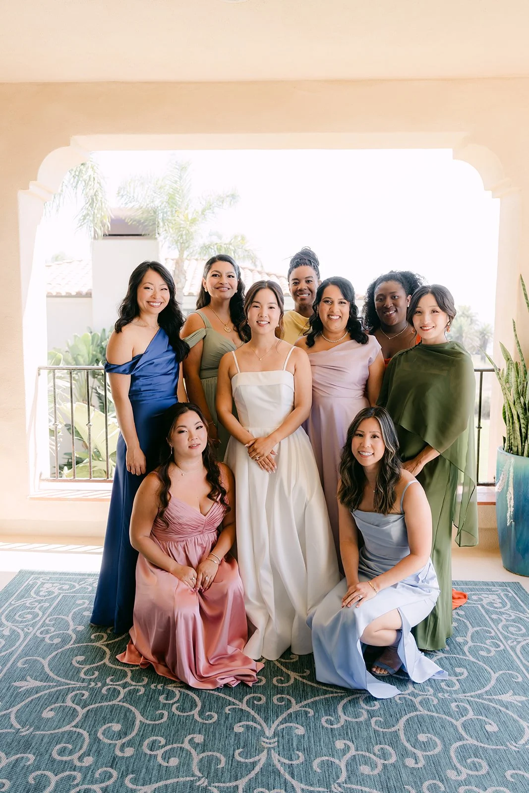 Saya with her bridesmaids in mismatched pastel gowns in the suite