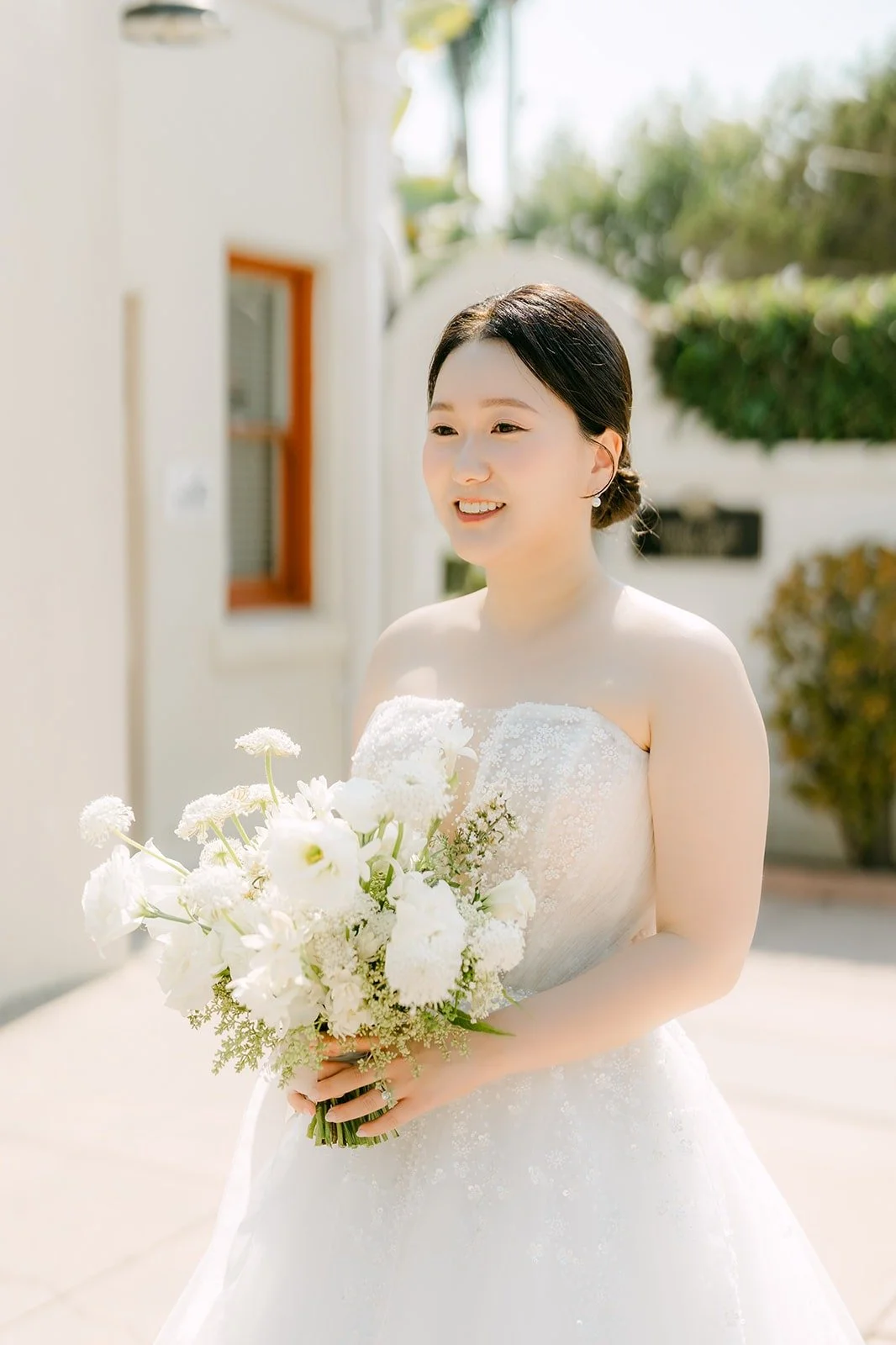 Amy smiling with her white bouquet
