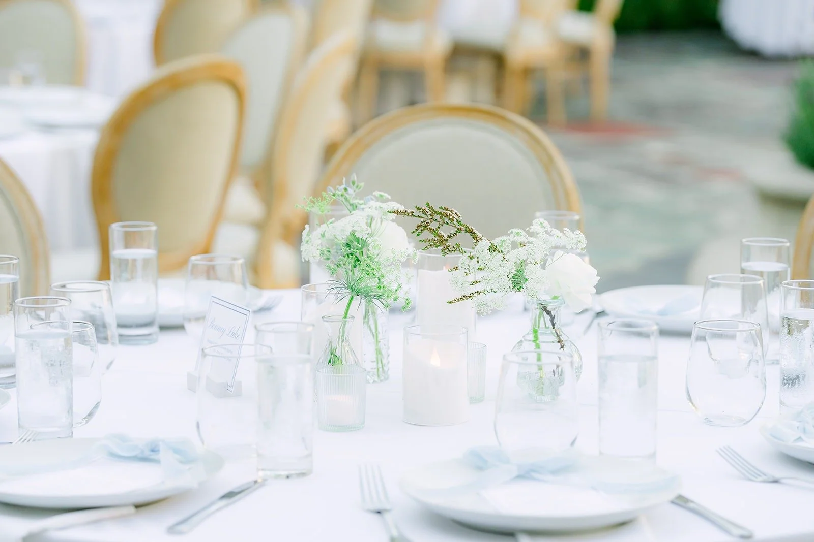 Place settings with white florals on the reception tables