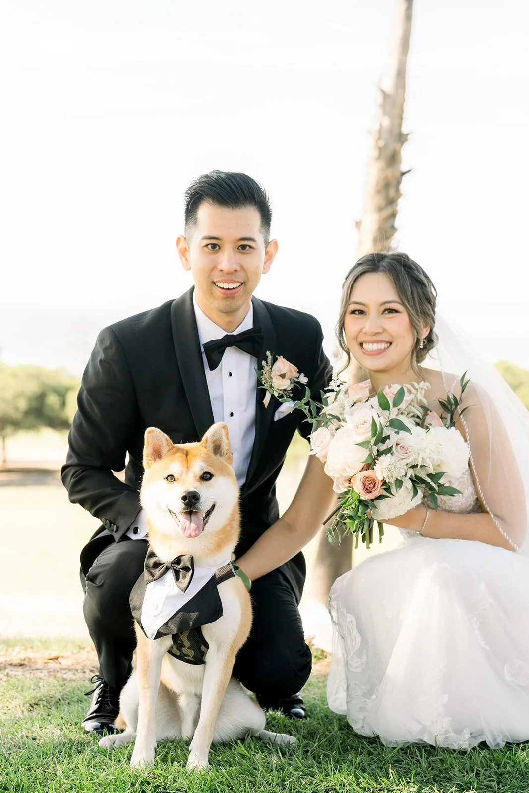 Josephine and David smiling with their dog on the lawn