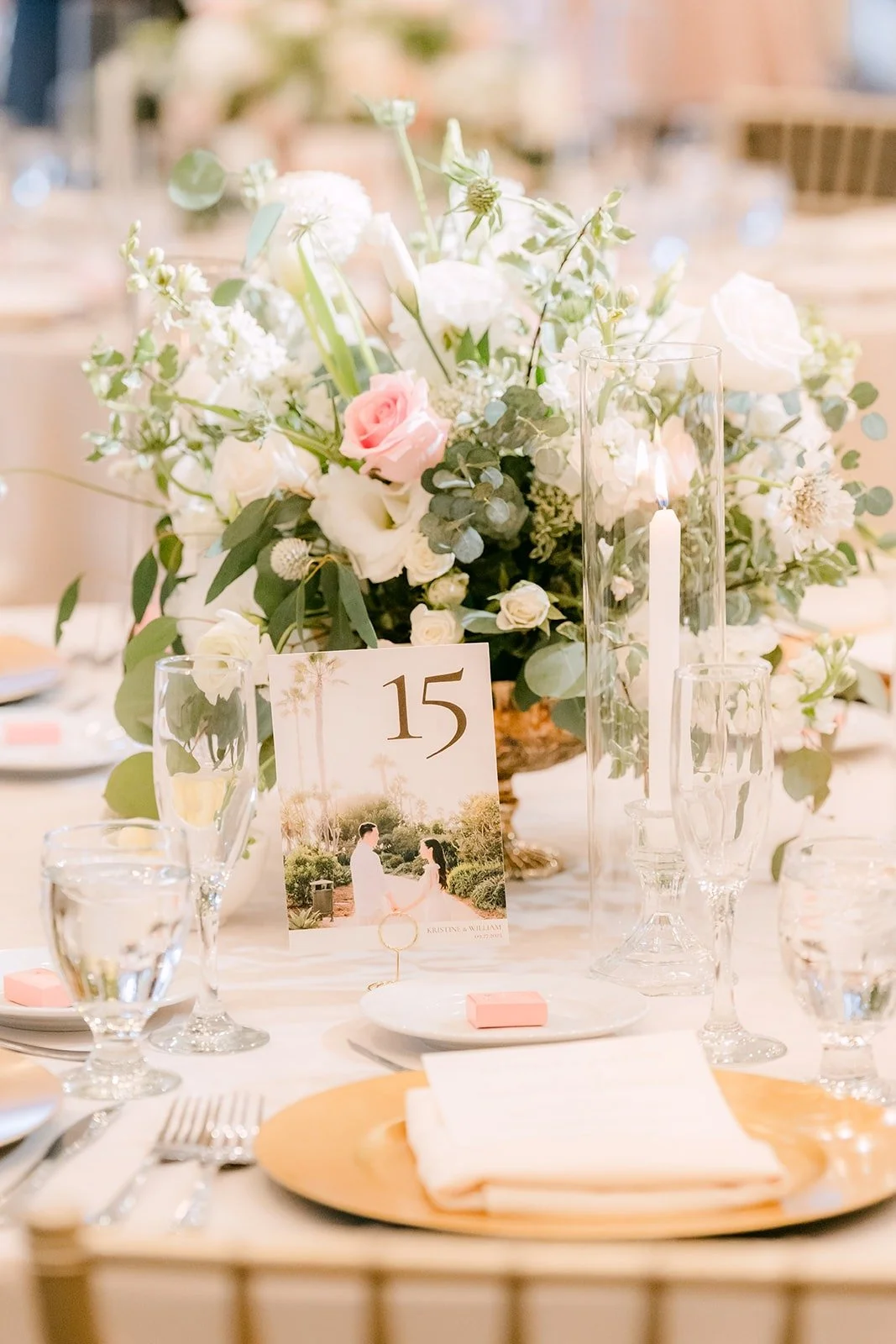 A floral centerpiece with blush roses and a table number