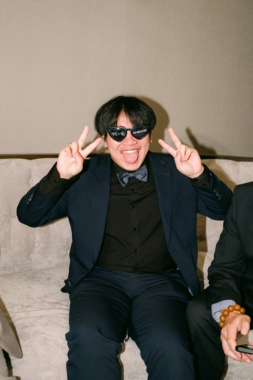 A guest throwing up peace signs in heart sunglasses.