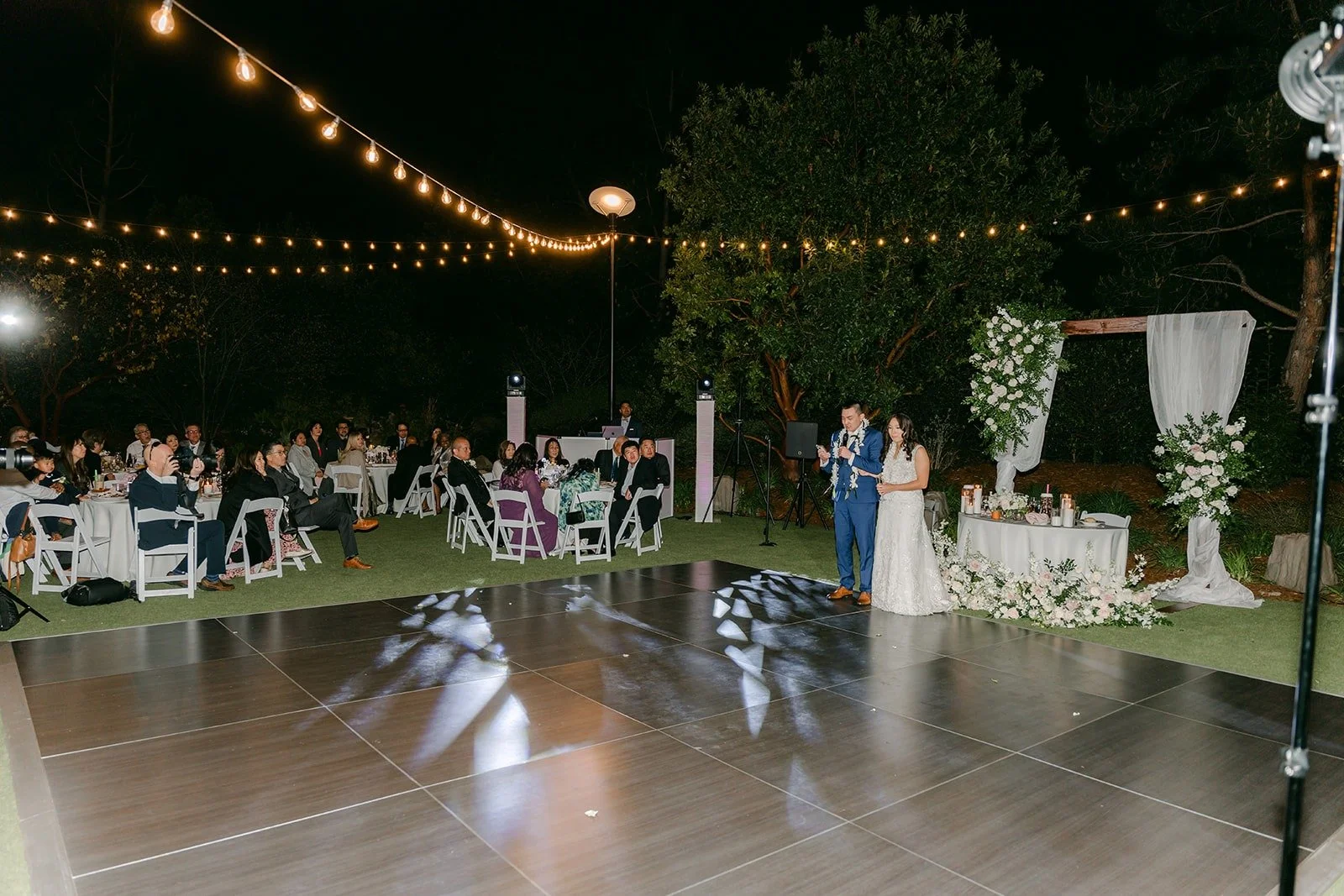 The reception at Los Robles Greens glowing under string lights after dark, photographed by One and Only Production