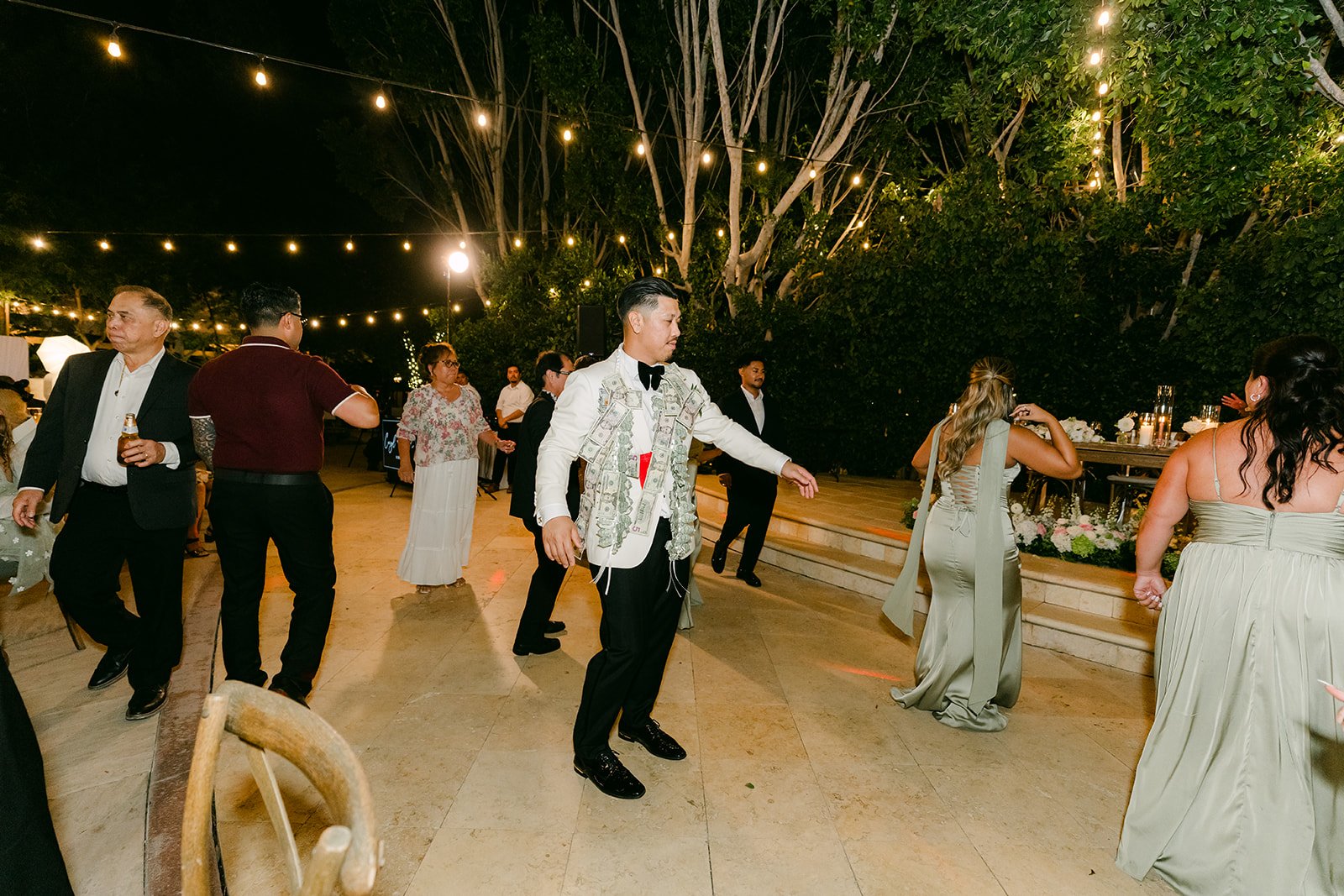 Caryl dancing with friends under the string lights.