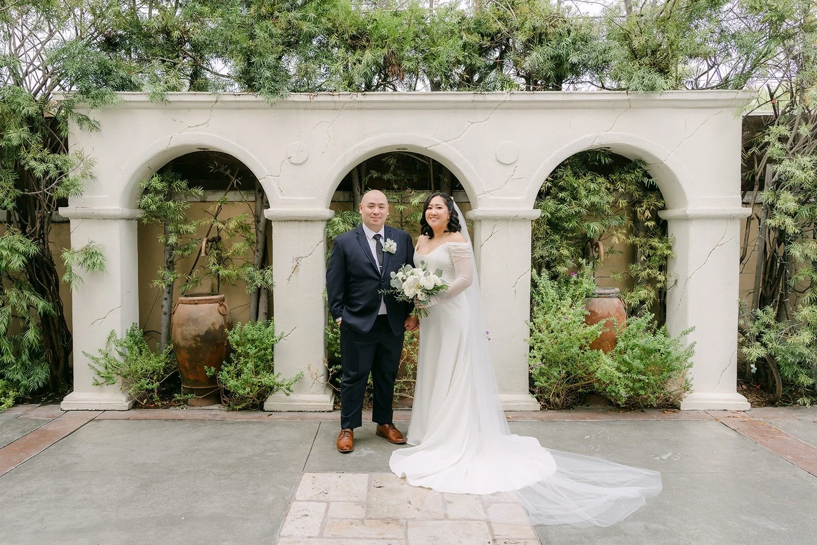 Vivian and Yao under the white arches of the courtyard