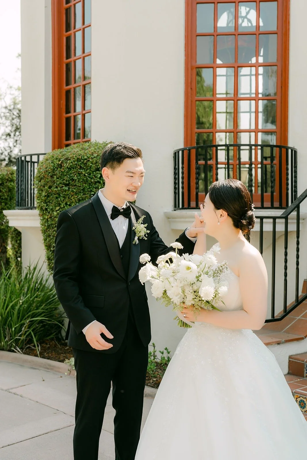 Amy and Sam holding hands beside the mansion