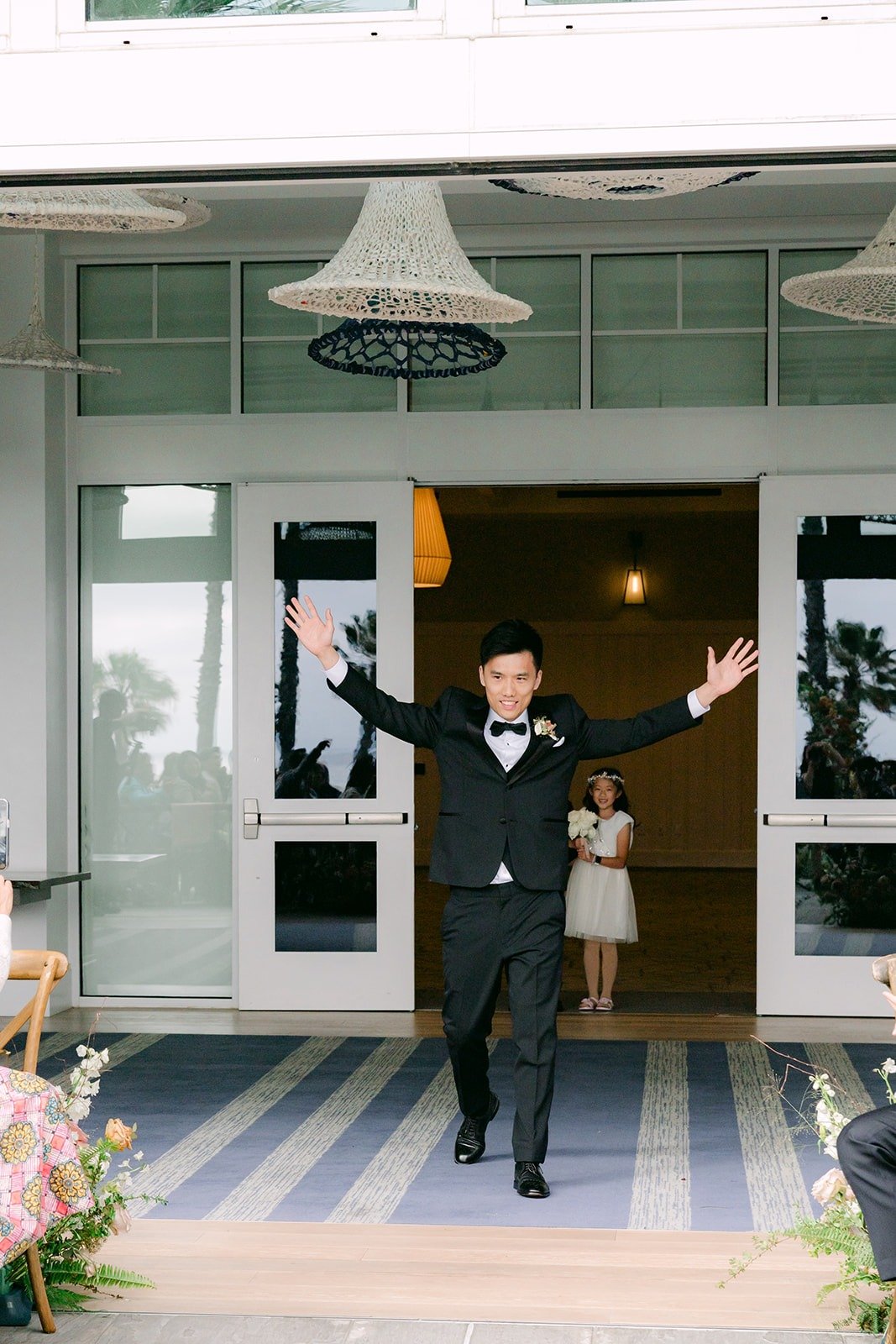 Eli walking out with both arms raised to start the ceremony