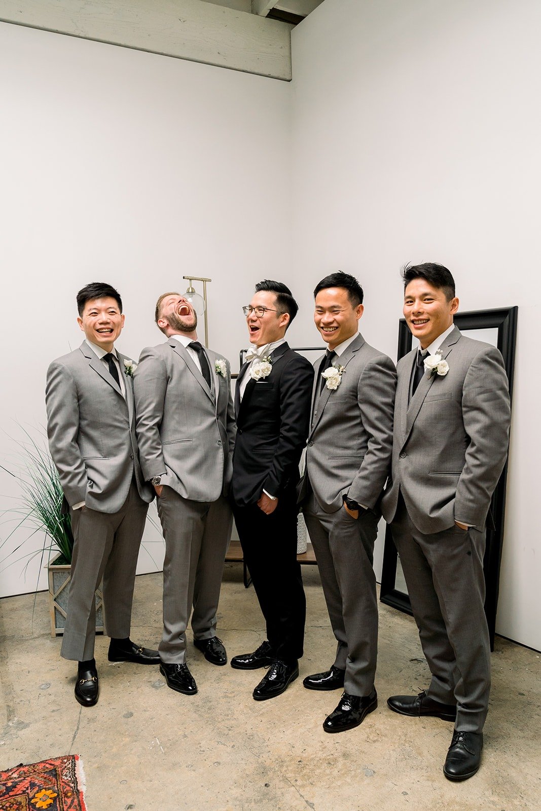 Alex with his groomsmen in grey suits