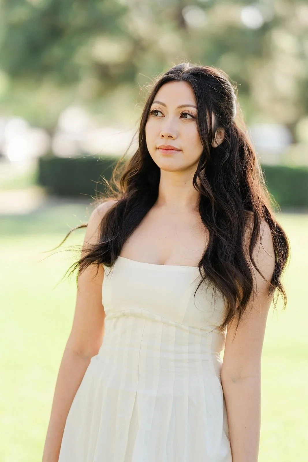 Victoria in a white dress with her long dark hair over her shoulders.