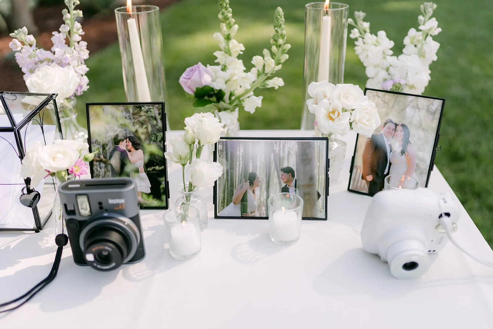 Guest book table with framed couple photos and instant cameras