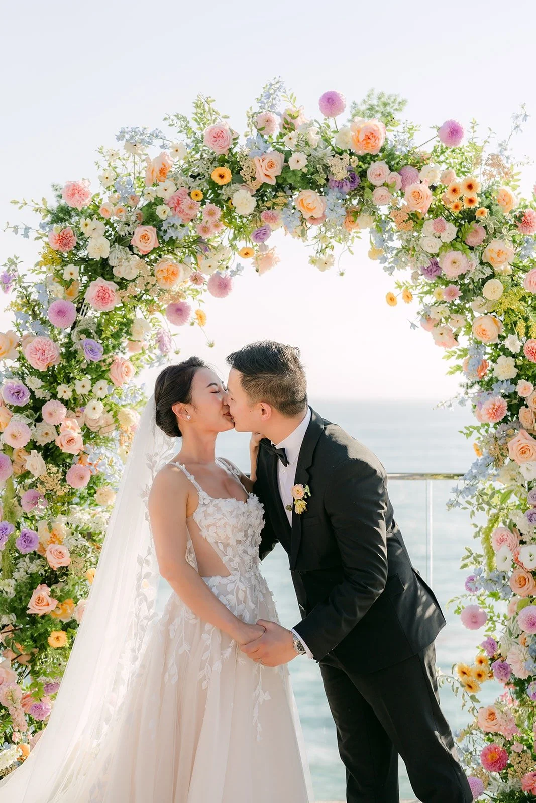 Kylie and Mario's first kiss as a married couple under the floral arch