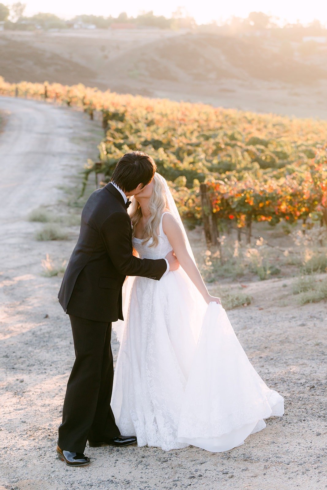 Konitha and Job kissing on the dirt road above the vineyard