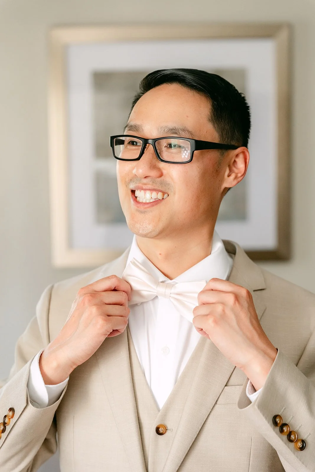 Kevin adjusting his bow tie on his wedding morning.