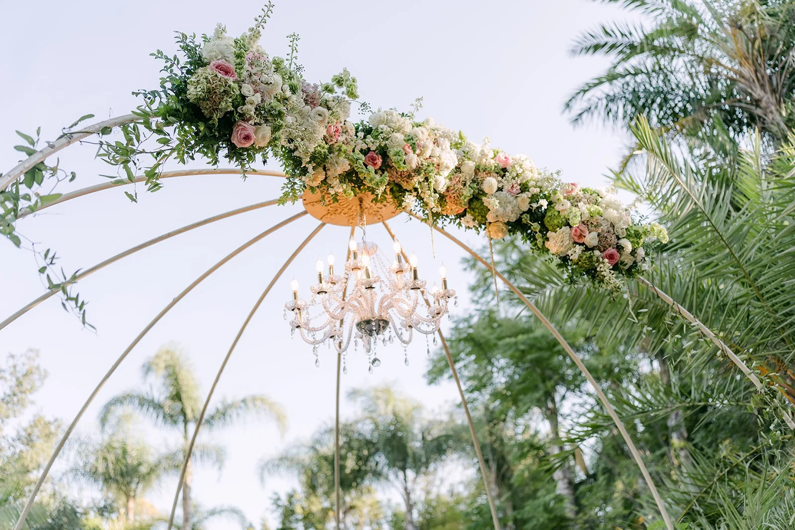 Blush roses and greenery on the domed ceremony arch at Eden Gardens.