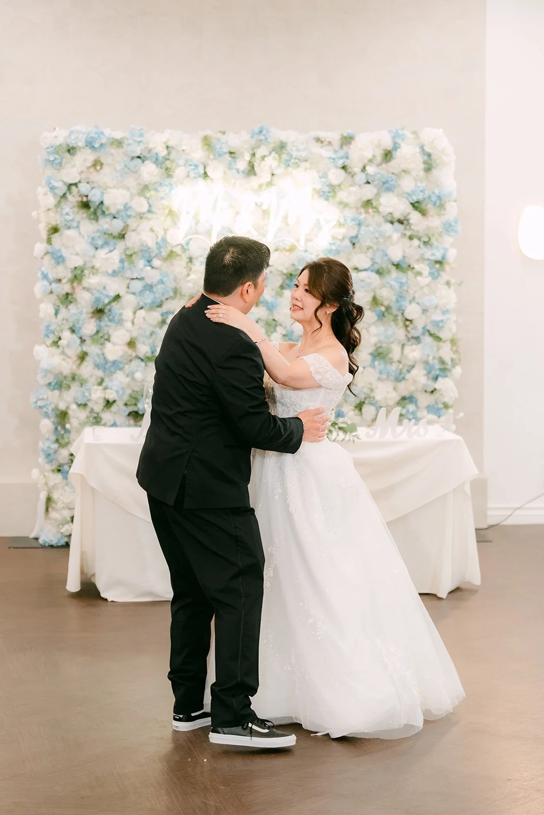 Sochi and Jay dance in front of the flower wall