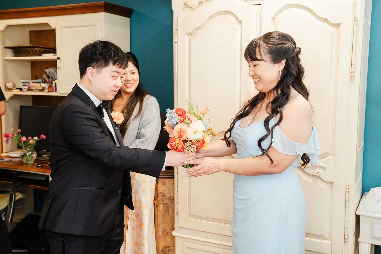 Henrik passing the bouquet to a bridesmaid in blue.