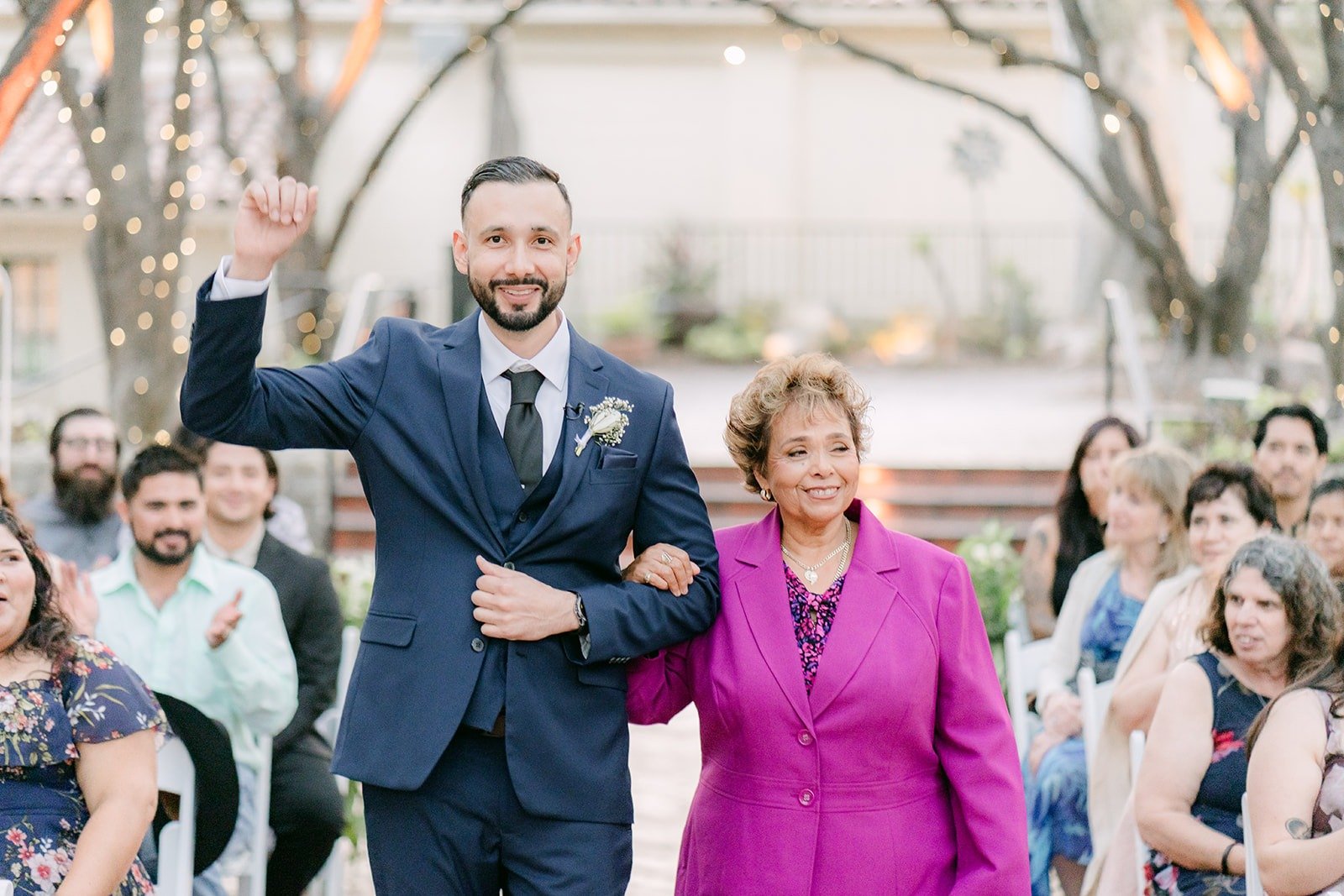 Danny waving as he walks down the aisle with a family member
