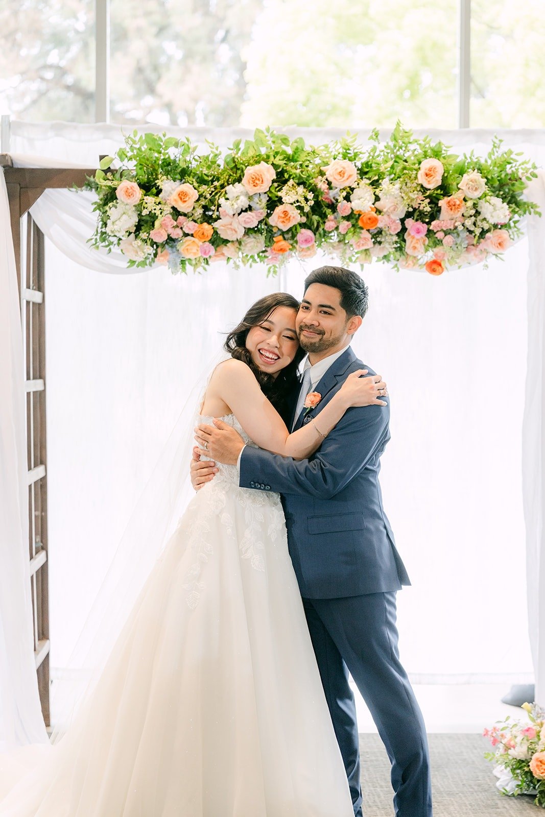Natalie and Mark embracing under the arch as husband and wife