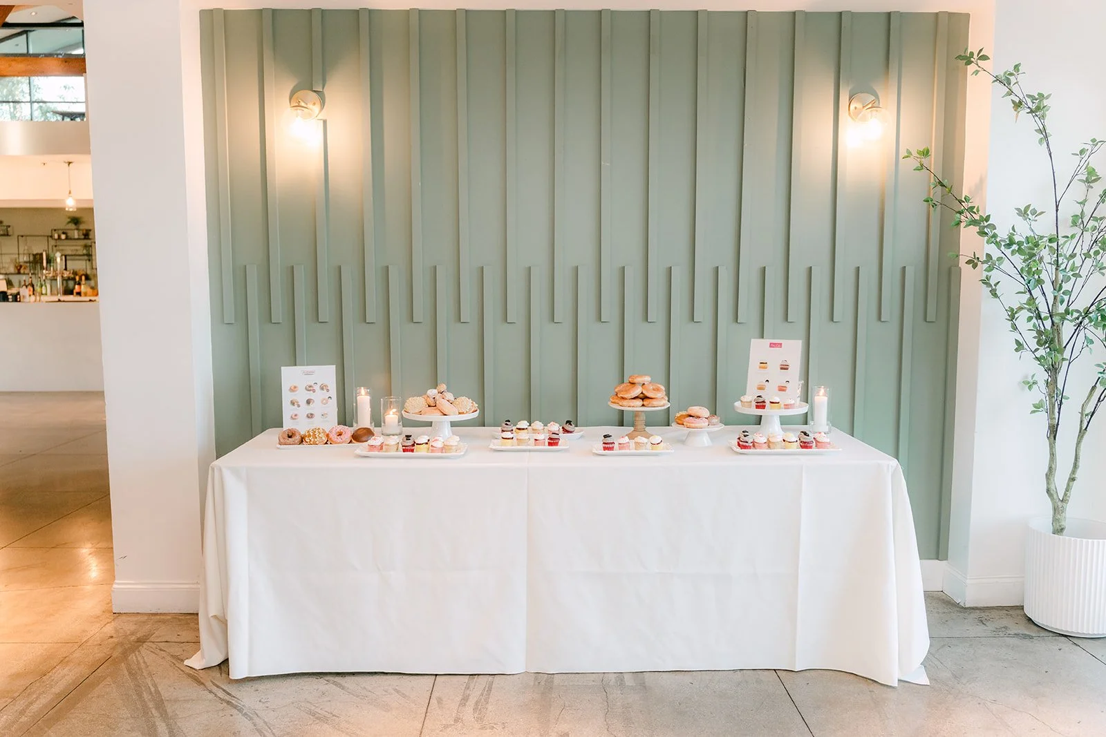 Dessert table against a sage green paneled wall
