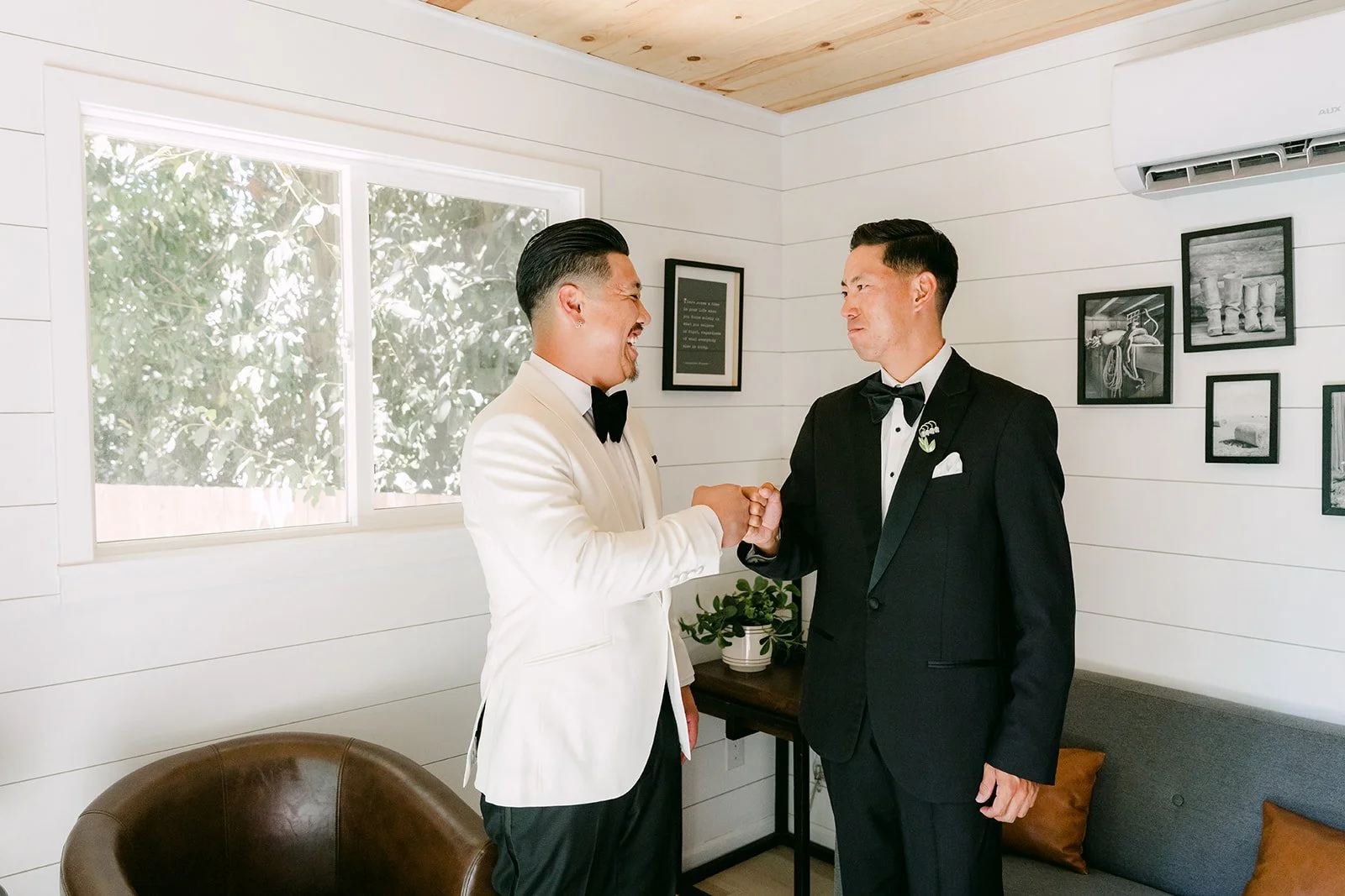 A groomsman helping Caryl with his white dinner jacket in the bungalow.