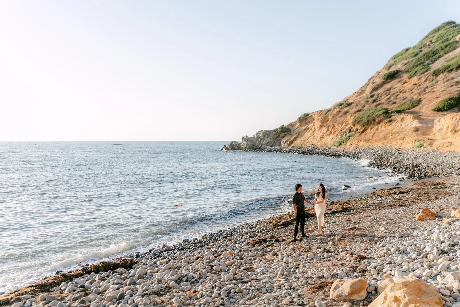 Victoria and Andrew walk along the rocky beach below the Palos Verdes bluffs.