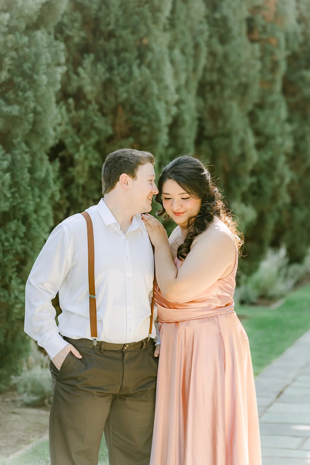 Saira leaning into Matthew between the cypress trees, photographed by One and Only Production.