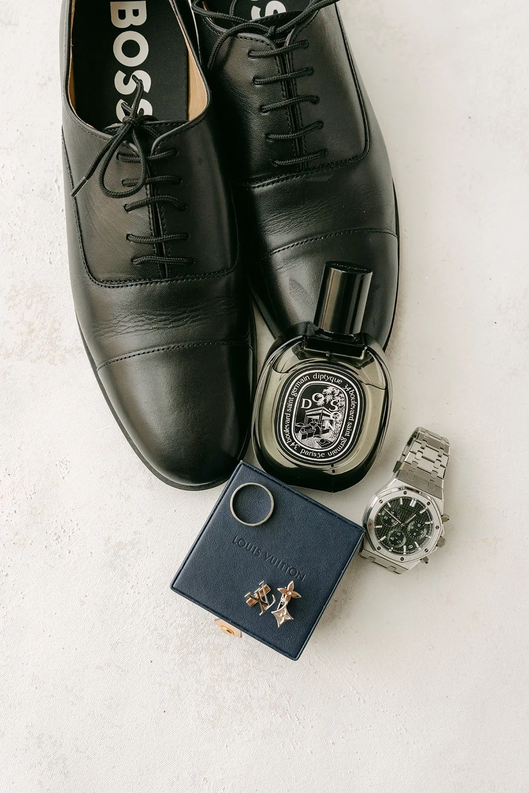 Mario's black dress shoes with his cologne, watch and cufflinks