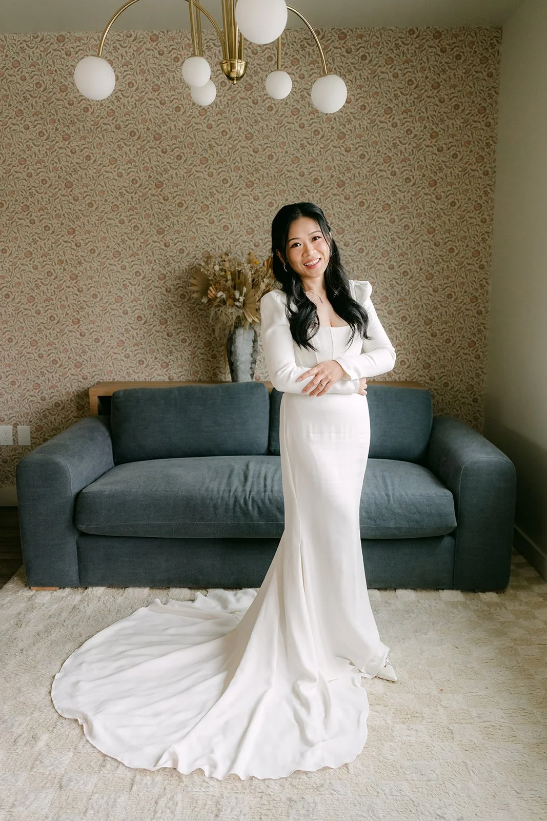 Full-length portrait of Denise in her gown with its long train in the bridal suite.