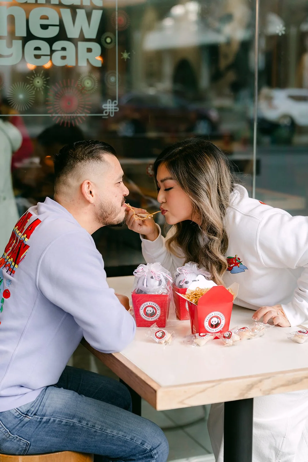 Ankush and Linh share a bite at the window table.