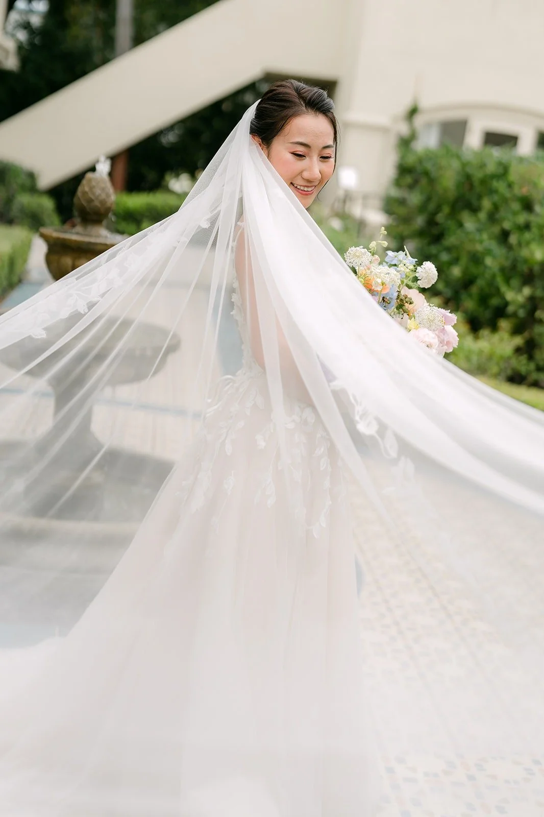 Kylie's long veil spread across the garden walkway at Surf & Sand Resort