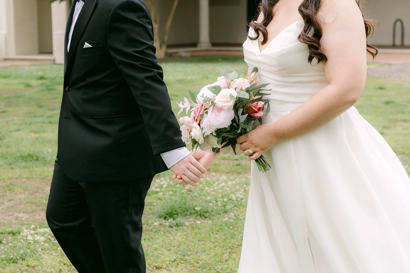 Matthew holding Saira's hand as she carries her blush rose bouquet, photographed by One and Only Production