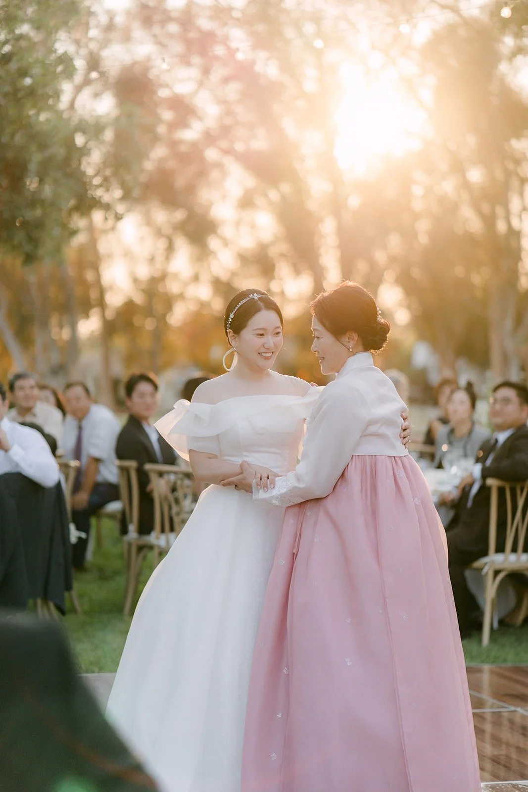Amy dancing with her mom in a pink hanbok at sunset