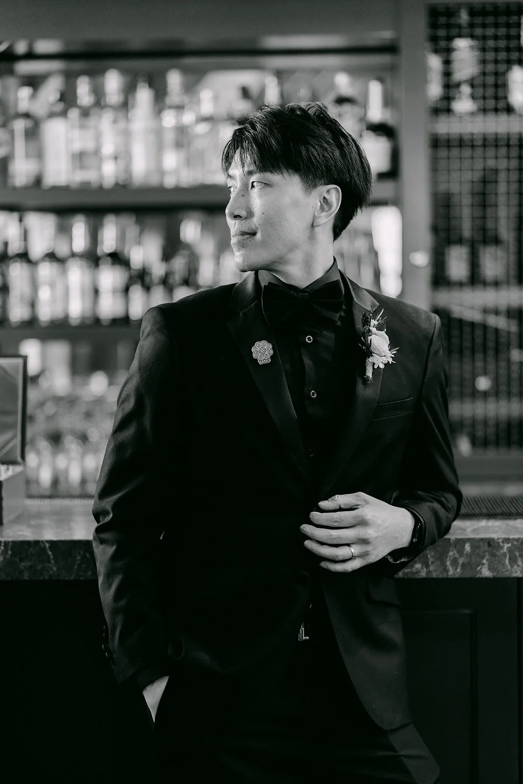 Fong by the bar in his tuxedo and boutonniere