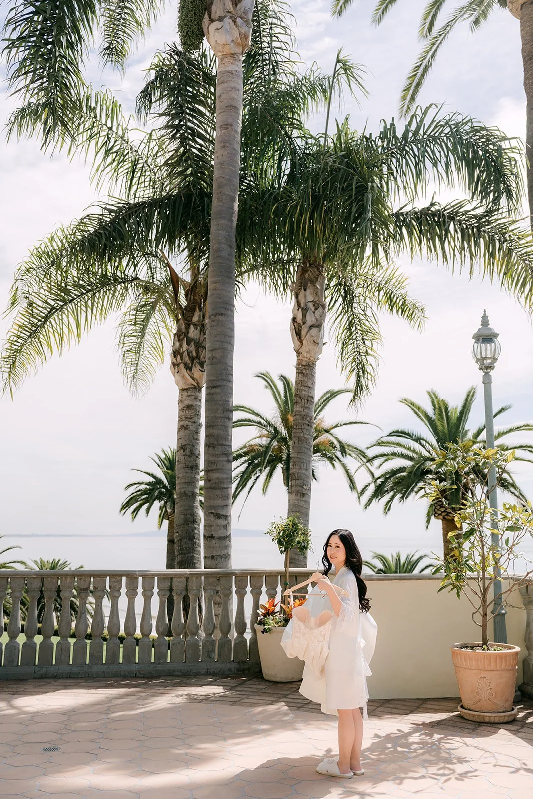 Bride on the terrace surrounded by palm trees and ocean views