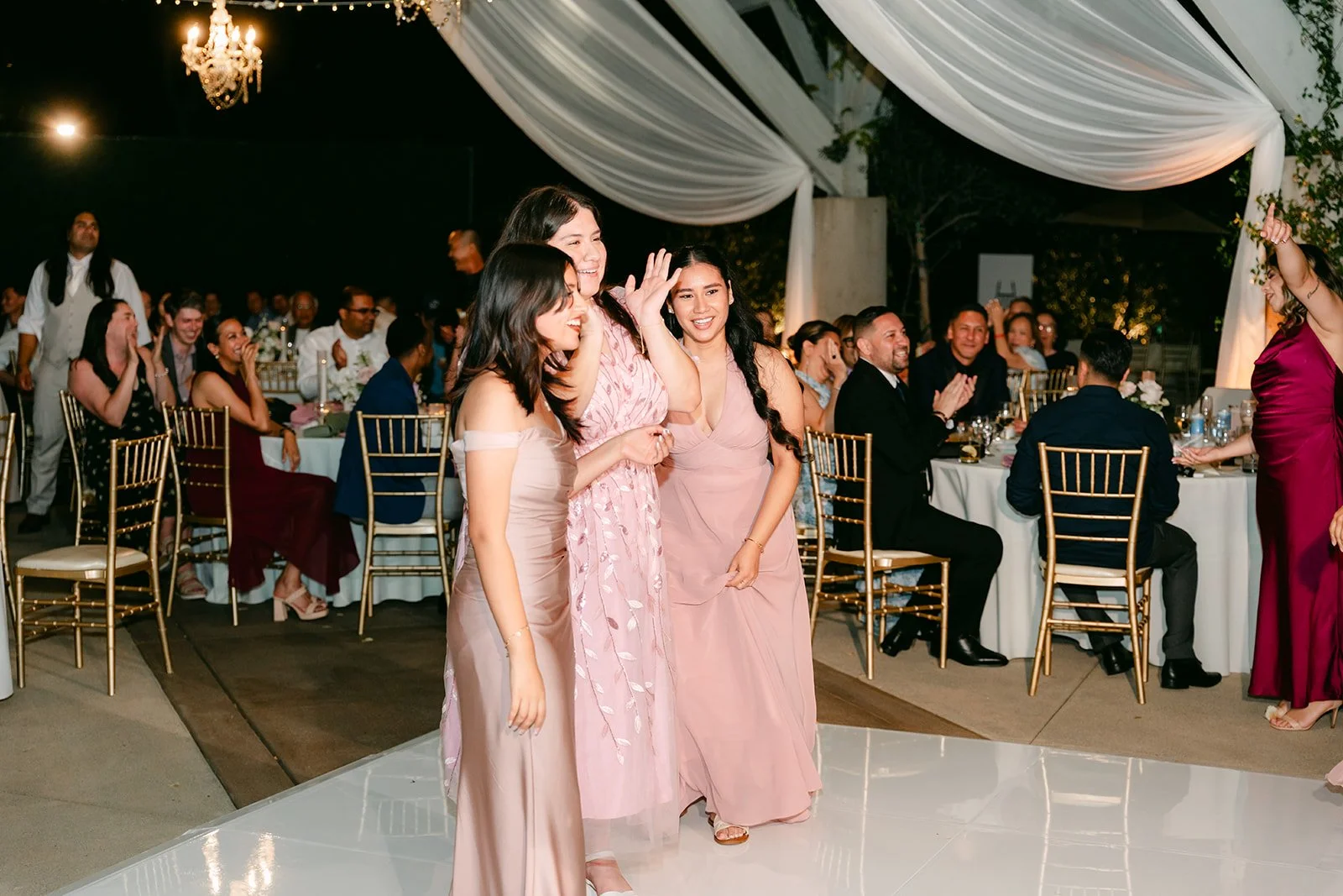 Bridesmaids lined up for the bouquet toss under the pergola.