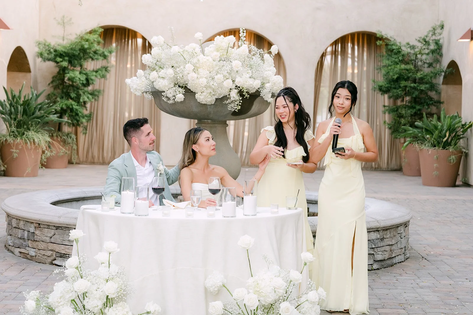 Sisters raising a toast beside the sweetheart table