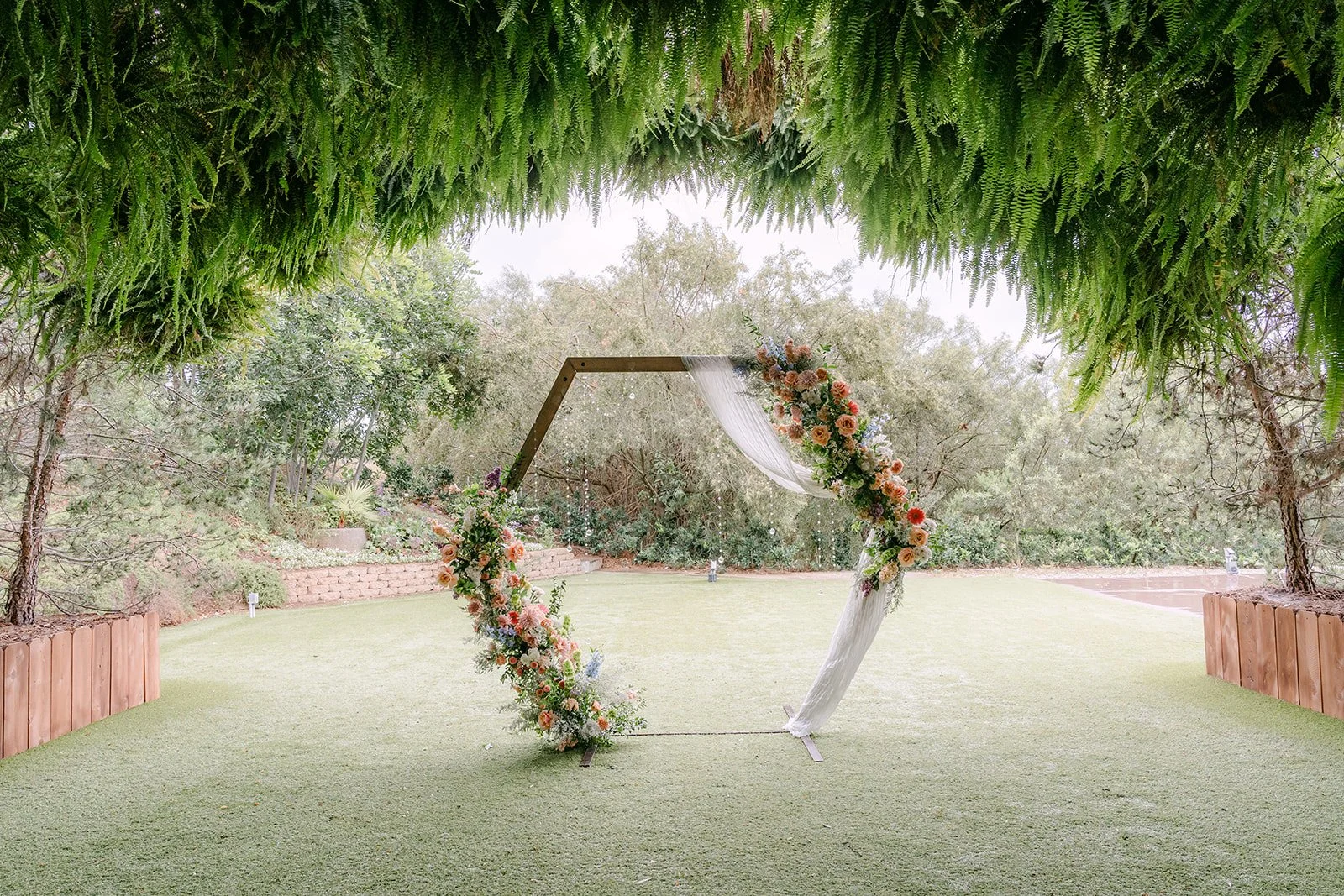 Hexagon ceremony arch with pastel florals in the grotto