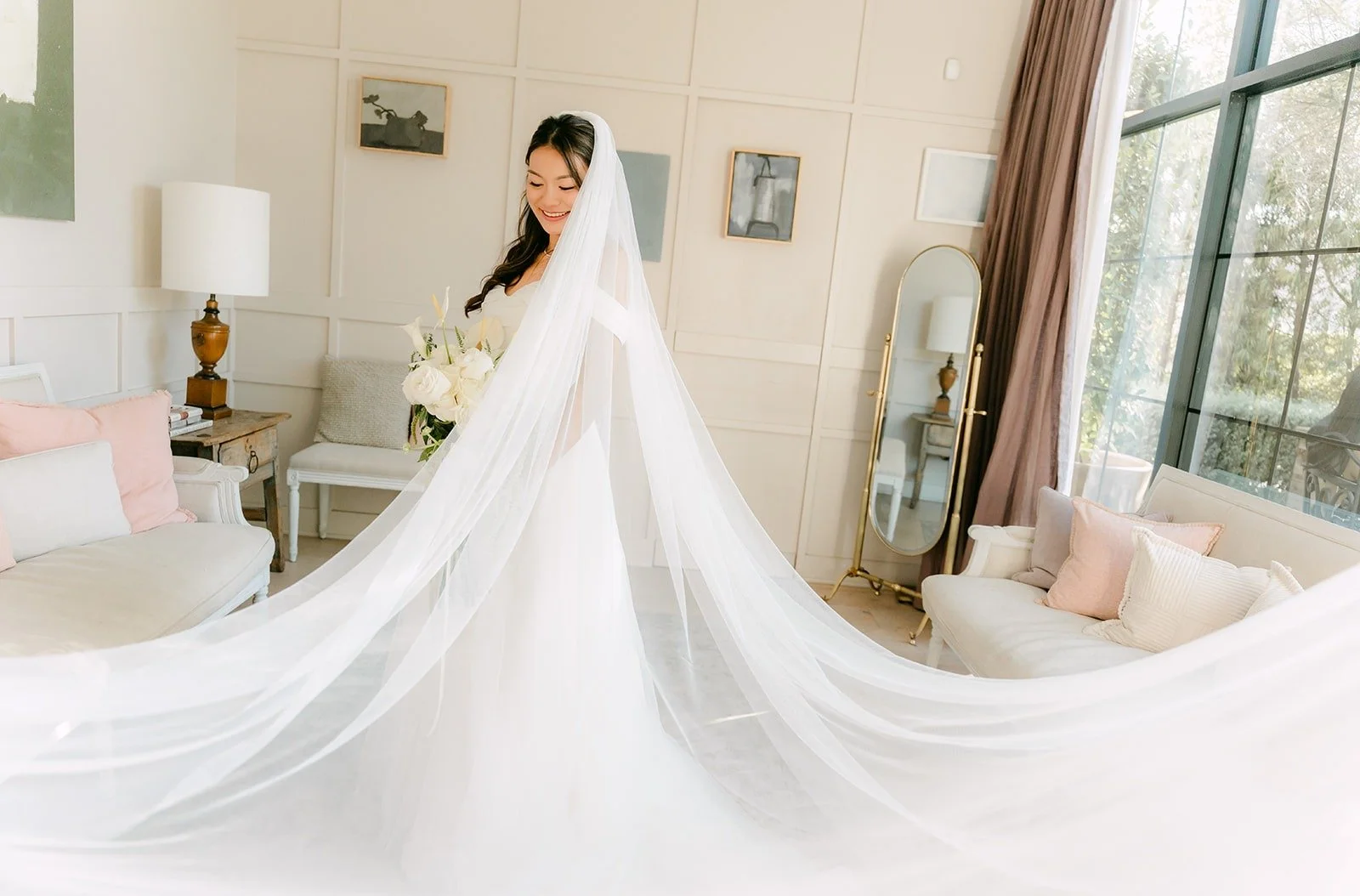 Jadee's long cathedral veil and train spread across the bridal suite