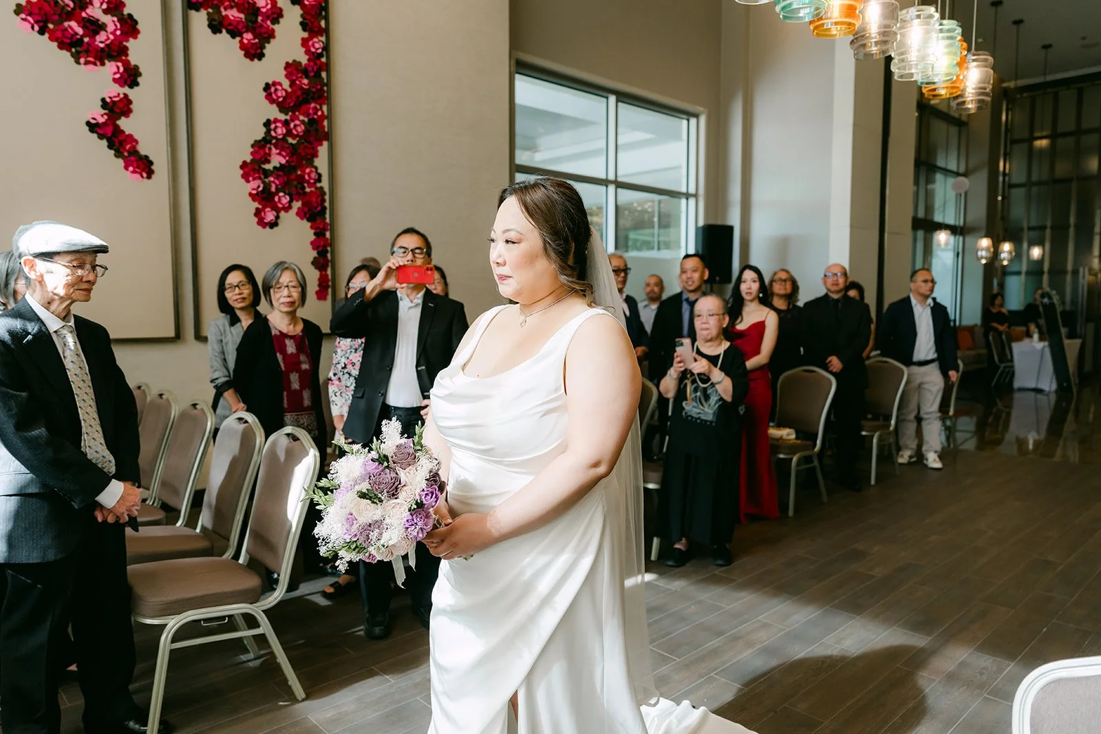 Mai walking down the aisle with her bouquet.