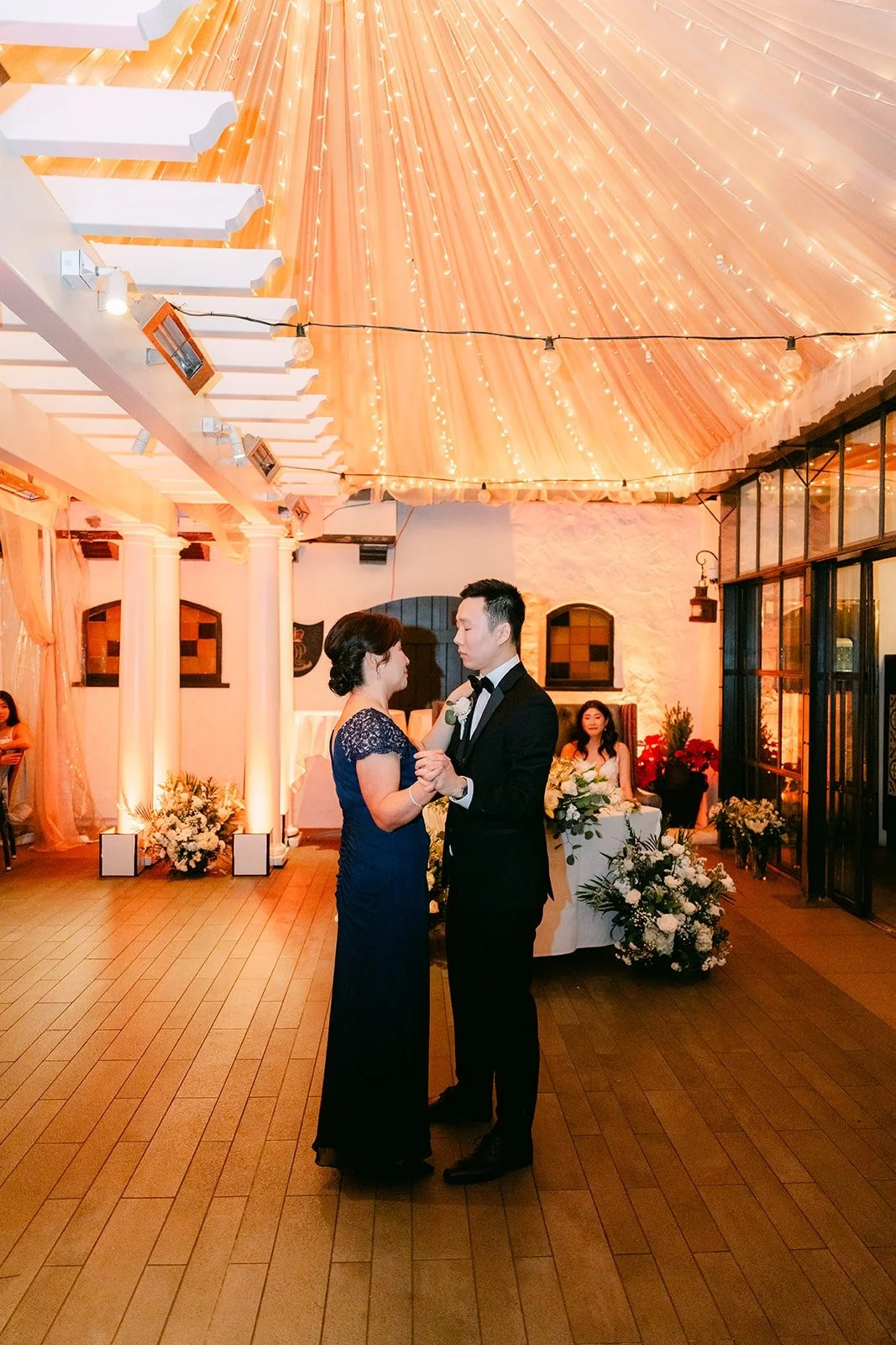 Jason dancing with a parent under the string lights
