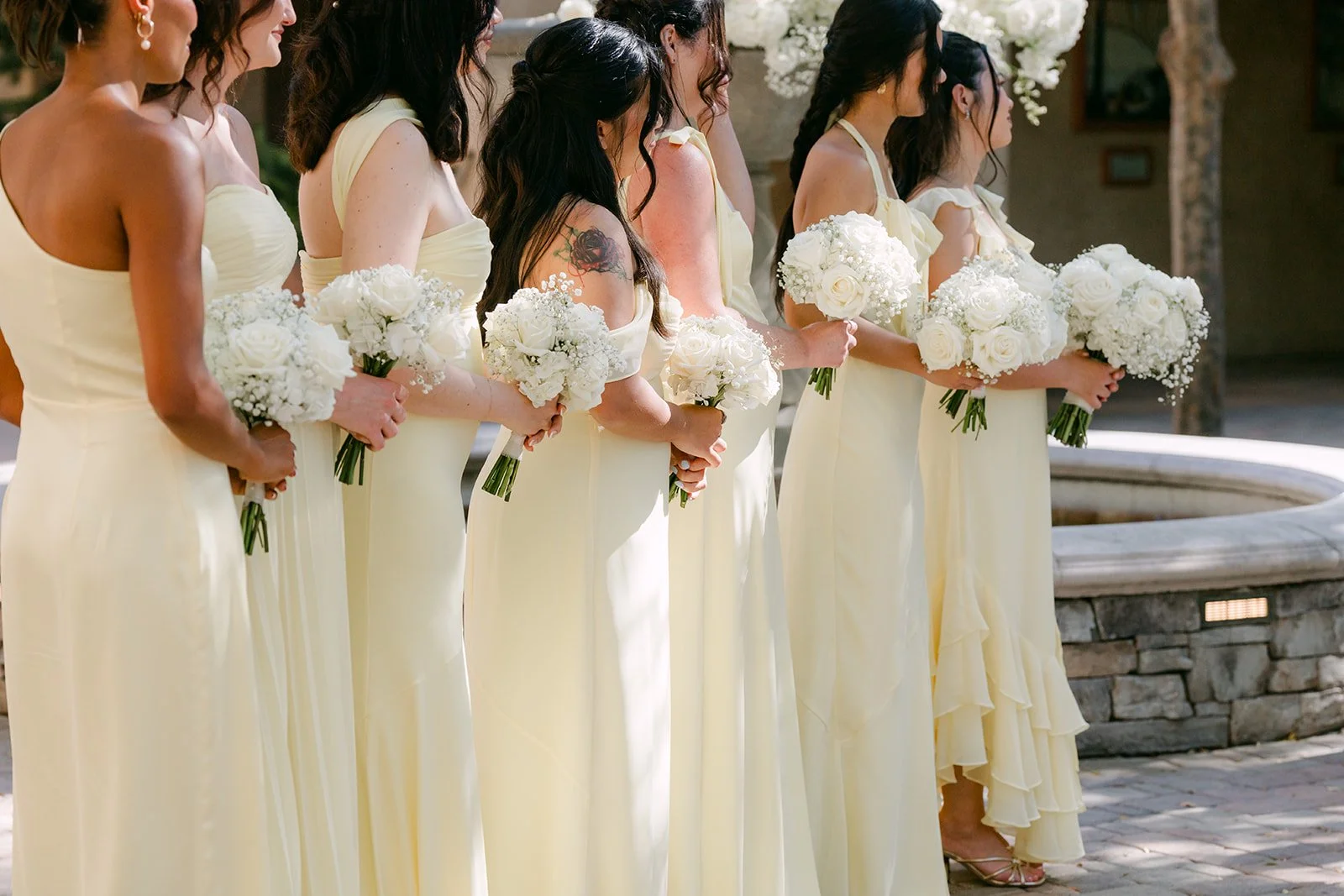 Bridesmaids lined up beside the fountain during the ceremony