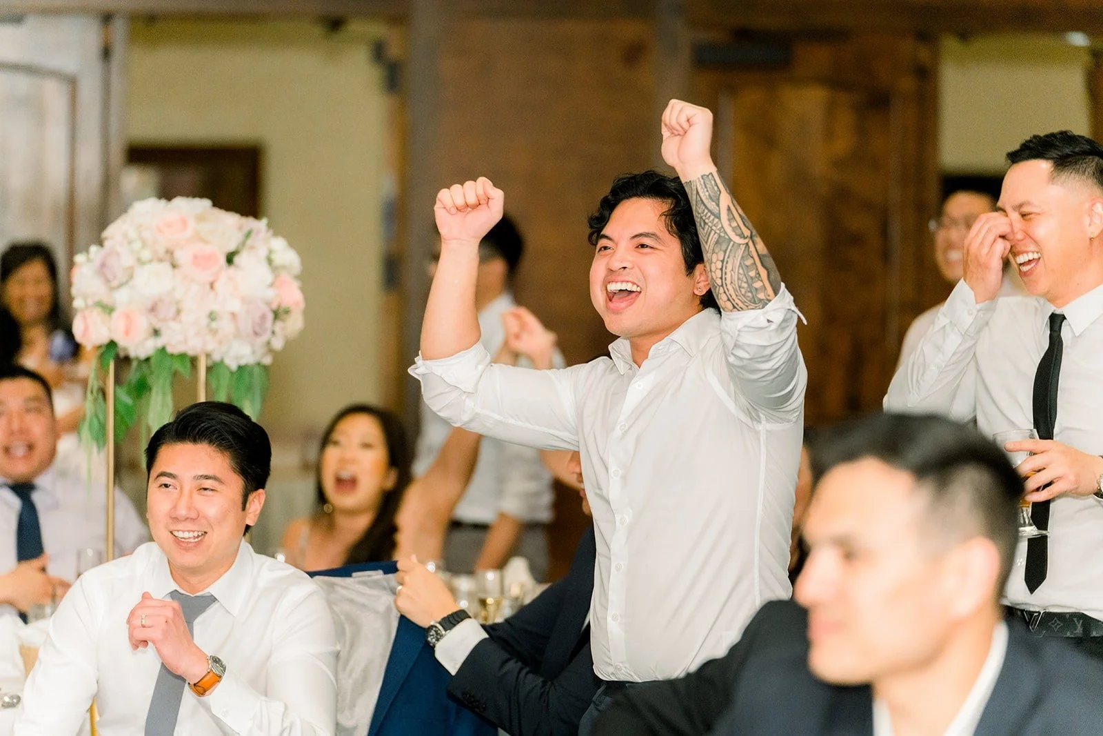 Guests raising their arms during a reception game, photographed by One and Only Production
