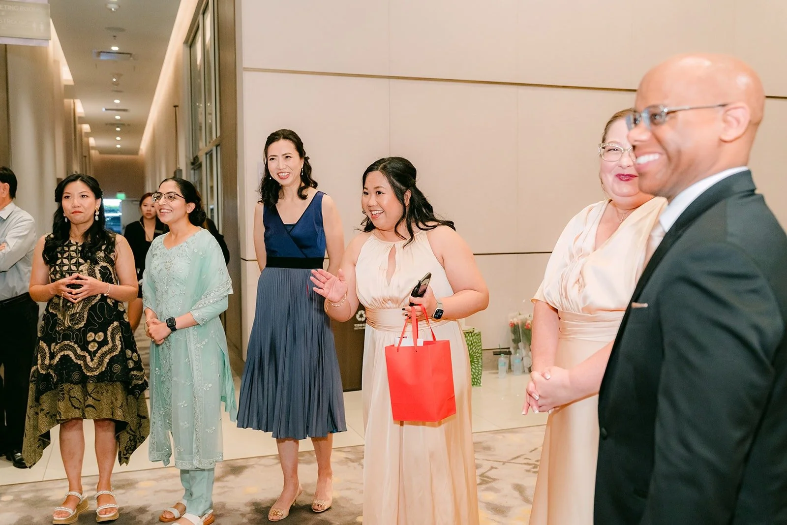 Bridesmaids lined up in a hotel hallway at the Sheraton Los Angeles San Gabriel, ready to start the door games