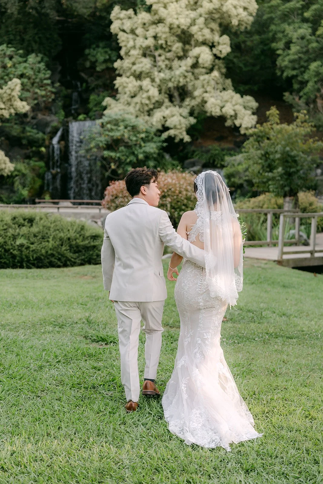 Elaine and Wen walking on the lawn near the waterfall.